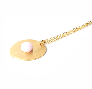 Pink open disc pendant from the PIB collection by PLATÓNICA. Gold plated silver and glass. Minimalist jewelry. Contemporary jewelry. Author jewelry. Made in Granada, Andalusia, Spain. Jewelry workshop in the Albaicín. Crafts. Hand-made jewelry. Jewels made from Andalusia. Geometry. Modern and sophisticated style.
